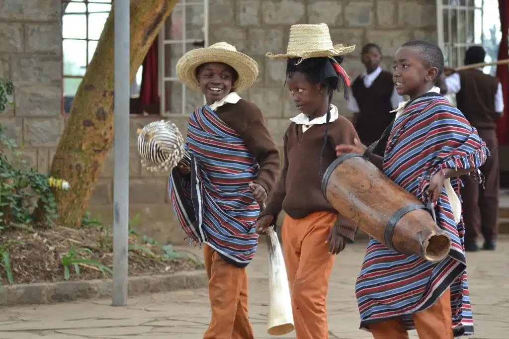 kinder gehen trommelnd durch eine stra&szlig;e