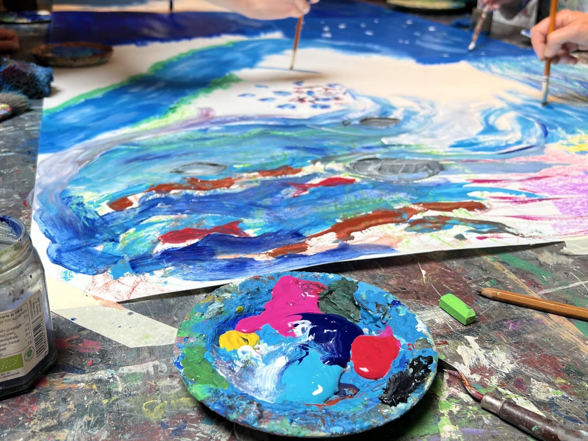 Schüler arbeiten mit Acrylfarben